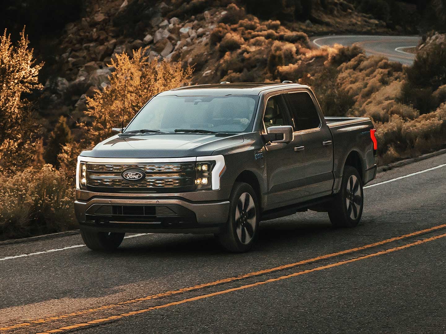 2025 Ford F-150® Lightning® pickup being driven on a mountainous roadway